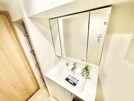 大きな鏡が備わった洗面台は空間をすっきりと見せてくれます。清潔感のある白を基調としたデザインです。収納棚も隣接しており洗面用品の整理に便利です。使い勝手の良さを感じられる洗面所です。
