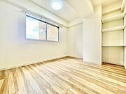 明るい光が差し込む洋室です。シンプルな内装で使いやすい空間が広がっています。収納棚も備え付けられておりすっきりと整理できます。清潔感のある印象が特徴です。