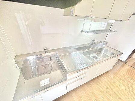 キッチンは明るく清潔感のある空間です。ステンレス製の作業台とシンクが広く使いやすい印象です。収納スペースも豊富で調理や片付けに便利です。上部にはオープン棚があり調理器具の整理もしやすいキッチンです。