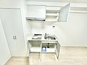白を基調としたキッチンは清潔感があります。収納スペースが上下にあり使い勝手が良いです。IHコンロが備わっています。シンプルな設計でお手入れもしやすいです。作業スペースも確保されています。