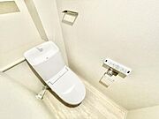 清潔感のあるシンプルなトイレ空間です。壁に設置された操作パネルで各種機能の操作が簡単です。すっきりとしたデザインでお手入れも手軽です。ペーパーホルダーやタオル掛けも使いやすい位置に配置されています。