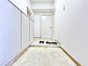 明るい色調でまとめられた玄関は空間が広く感じられます。収納スペースも豊富に確保されています。段差部分がアクセントとなりメリハリのあるデザインです。シンプルで清潔感のある雰囲気です。