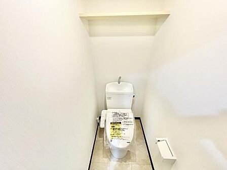 シンプルなデザインで清潔感を感じるトイレです。壁には収納棚が設置されており使い勝手にも配慮されています。スペースにもゆとりがあり快適にご利用いただけます。床材も手入れが簡単な仕様です。