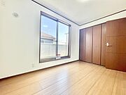 明るい日差しが差し込む開放感のある洋室です。大きな窓から外の景色も楽しめます。落ち着いた木目調のフローリングと建具が調和しています。クローゼットも備わっており収納にも対応しています。