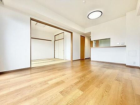 リビングは開放感のある空間で隣接する和室との一体感が特徴です。明るいフローリングが室内をすっきりと見せています。カウンターキッチンも設けられており便利です。