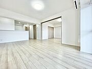 リビングは明るく開放感のある空間です。ホワイト系のフローリングが広さを引き立たせています。バリアフリーを意識したフラットな床面が特徴です。収納スペースも豊富で使い勝手が良いです。