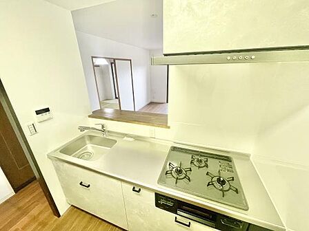 キッチンはゆとりのあるスペース設計で使いやすい配置です。カウンター越しにリビングが見渡せます。シンクも広めで作業効率が高まります。収納も十分に備わっています。清潔感のあるデザインです。