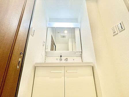 明るく清潔感のある洗面台が特徴です。大きなミラーが設置されており日々のお手入れに便利です。収納スペースも確保されており整理整頓しやすい仕様です。すっきりとしたデザインで使い勝手の良い空間です。