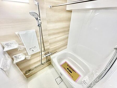 明るく清潔感のあるバスルームです。壁面のナチュラルなデザインが空間に落ち着きを与えます。使いやすいシャワーや棚も備わっています。浴槽はゆったりとしたサイズ感が特徴です。