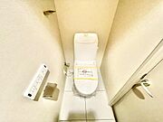 シンプルですっきりとしたトイレスペースです。ホワイトを基調とした清潔感のある内装です。ウォシュレット機能付きで快適にご使用いただけます。ペーパーホルダーやリモコンが壁付けでまとまっています。