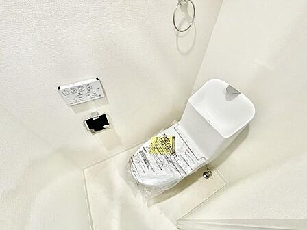 明るい色調でまとめられた清潔感のあるトイレです。壁面にはペーパーホルダーやコントロールパネルが設置されています。スペースも十分に確保され使い勝手が良い印象です。