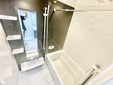 シンプルで清潔感のあるバスルームです。壁面の収納棚が便利に使えます。大きめの鏡が設置されており使い勝手も良好です。浴槽もゆったりとしたサイズ感です。シャワースペースが独立しておりお手入れも簡単です。