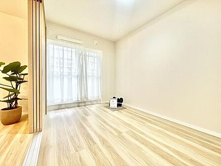 洋室は明るいナチュラルなフローリングが特徴です。大きな窓からやわらかな光が差し込みます。シンプルで使いやすい空間設計となっております。可動式の仕切りがアクセントです。家具の配置もしやすい洋室です。