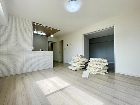 明るい日差しが差し込むリビングは白を基調とした内装で広がりを感じられます。キッチンとの仕切り壁にはタイル調のデザインが施され空間にアクセントが加えられています。