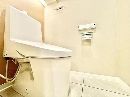 清潔感あふれるトイレ空間です。明るく広々とした印象で快適にご利用いただけます。壁面もシンプルでお手入れがしやすいデザインです。ペーパーホルダーや操作パネルも使いやすい位置に設置されています。