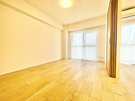 明るい印象の洋室です。二面に窓があり日差しがしっかり入ります。フローリングの質感が空間全体をやさしく演出します。シンプルな内装なので家具の配置がしやすいです。
