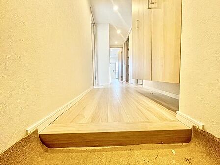 明るい色合いの玄関が空間全体をすっきりと見せています。廊下まで続くフローリングが統一感を演出。玄関収納も備わっており使い勝手が考えられた設計です。