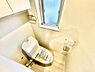 トイレ：明るい採光のあるトイレです。壁に設置された収納スペースが空間を有効活用しています。窓があるため換気もしやすく衛生的です。床は清潔感のある色合いでお手入れもしやすい設計です。