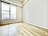 洋室：明るい光が差し込む洋室です。シンプルな白い壁と木目調の床が空間を引き立てます。大きな窓から外の景色も楽しめます。清潔感のある雰囲気です。家具の配置もしやすい造りです。
