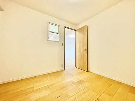 明るい色合いのフローリングが魅力の寝室です。シンプルな造りが空間を広く感じさせます。窓と扉のバランスが良く通風や採光も十分に期待できます。照明の配置にもこだわりが見られます。