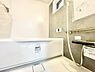 浴室：ホワイトを基調とした明るいバスルームです。壁の落ち着いた色合いが空間に調和しています。浴槽はゆったりとしたサイズ感で床のデザインにもこだわりが感じられます。浴室内には窓があり換気にも配慮されています。