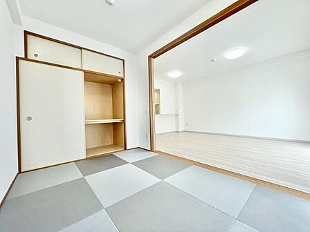和室と洋室がひと続きになった開放的な空間です。押入れ収納がありすっきりと片付けられます。明るい室内でシンプルなデザインが魅力的です。畳の市松模様がアクセントになっています。