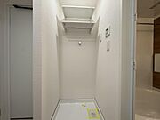洗濯機置き場の上には、洗剤やタオルを置ける便利な棚と室内干しに活躍する物干し竿掛けを完備。忙しい子育て世代の家事をスムーズにサポートする、機能的な空間です。