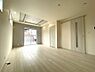 室内：白を基調とした温かみのあるリビング。明るい床と白いクロスが広々とした空間を演出。