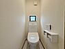 トイレ：白を基調とした清潔感のあるトイレスペースです。手洗い一体型の多機能トイレを採用し、限られた空間を賢く活用。温かみのある木目調のフロアが落ち着いた雰囲気を醸し出し、毎日の生活に心地よさを提供します。
