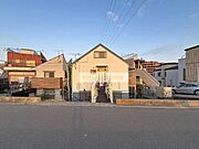 前面道路が広く車の出入りがしやすい環境です。建物前に開放感があり周囲も整然とした住宅が並んでいます。日当たりの良さを感じられる現地写真です。物件の外観がシンプルで落ち着いた印象を与えています。