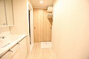 洗面化粧台の入りg淵からの風景です。右奥が洗濯機置き場になります。防水パンと洗濯用水栓があります。