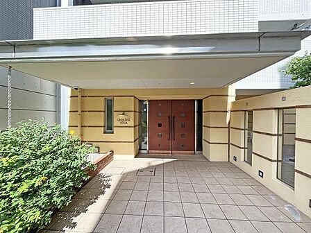 重厚感ある木製ドアと緑に彩られたエントランスが出迎える「クレッセント用賀」。帰るたびに上質な暮らしを実感できる、風格ある共用空間です。