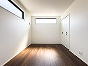柔らかな光が差し込む明るい洋室。お子様の感性を育む美しい空間です。白と黒のモダンなコントラストが、家族の物語をスタイリッシュに彩ります。