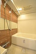 木目調のアクセントパネルが落ち着いた印象のバスルーム。ゆったり浸かれる浴槽で、一日の疲れを癒せる清潔感のある空間です。※室内写真は家具を含めCGでイメージ加工を施しています