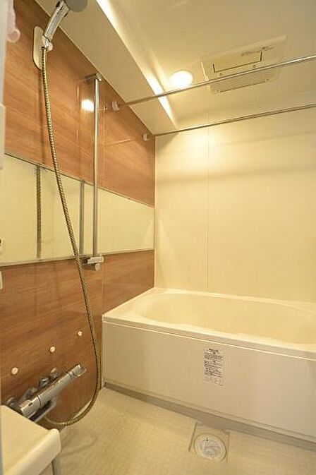木目調のアクセントパネルが落ち着いた印象のバスルーム。ゆったり浸かれる浴槽で、一日の疲れを癒せる清潔感のある空間です。※室内写真は家具を含めCGでイメージ加工を施しています