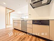 機能性とデザイン性を兼ね備えたシステムキッチン。リビングとの一体感も考慮され、美しい空間が実現。