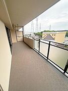 バルコニーが広めに設計されておりゆとりある空間が広がっています。落ち着いた色合いで清潔感があります。高い位置からの眺望が開放感を与えます。ガラスパネルの手すりで明るさも確保されています。