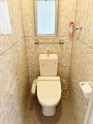 窓付きのトイレで採光や換気がしやすい点が特徴です。壁や床の清潔感のある仕上がりで落ち着いた雰囲気があります。温水洗浄便座が設置されており使い勝手も考慮されています。手洗い部分もついて便利です。
