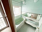 広々とした浴室で窓から自然光が入る明るい空間です。ミラーや棚も備わり使い勝手の良さが感じられます。清潔感のあるデザインが特徴的です。浴槽もゆったりとしたサイズとなっています。