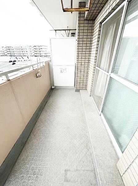 【一部AIモノ消し済み・実際の室内状況優先】奥行きがありゆとりを感じられるバルコニーです。ガラス窓から自然光が差し込み明るい空間となっています。手すり部分の見通しも良く圧迫感を感じにくい設計です。