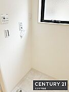 室内洗濯機置き場。白を基調とした洗面所で明るい雰囲気を感じられます。窓が設置されているため換気もしやすい設計です。床面は清掃しやすい素材が採用されています。