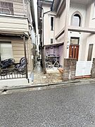 自転車やバイクが置けるスペースが確保されています。周囲の住宅とも程よい距離感があります。路面は舗装されており日常的に使いやすい環境です。コンパクトな外観が印象的です。