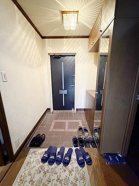 収納スペースも充実しており靴の整理に便利です。落ち着いた色合いの床と扉が全体の雰囲気を引き締めています。清潔感のある玄関が魅力的です。