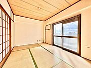 大きな窓からしっかりと光が差し込む和室です。障子と畳が落ち着いた雰囲気を演出しています。天井や壁もシンプルですっきりとした空間が広がります。エアコン設置用の配線も整っています。