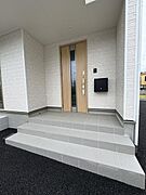屋根付きの広い玄関ポーチで、雨の日も濡れずに荷物の出し入れができます。ベビーカーや宅配の一時置きにも重宝するゆとりの空間です。