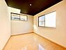 寝室：二面に窓があり日差しがたっぷりと差し込む明るい寝室です。木目調の床が温かみをプラスし、シンプルな内装で家具の配置がしやすい空間になっています。