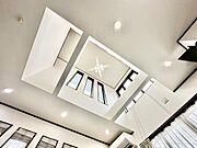 【約16帖】開放感のある吹き抜けが魅力的なリビングです。天井が高く室内がより明るく感じられます。複数の窓から差し込む光が空間を広くみせます。モダンなデザインが印象的です。