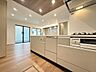 キッチン：木目調の床と対面式キッチンを備えた室内