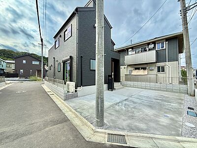 外観：道路沿いに建つ住宅外観と敷地内の駐車スペース