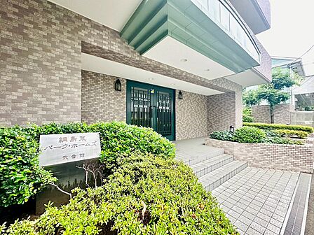 建物入口付近の外観と緑豊かな植栽の様子